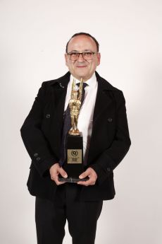 Lalo España con el premio de la revista Q